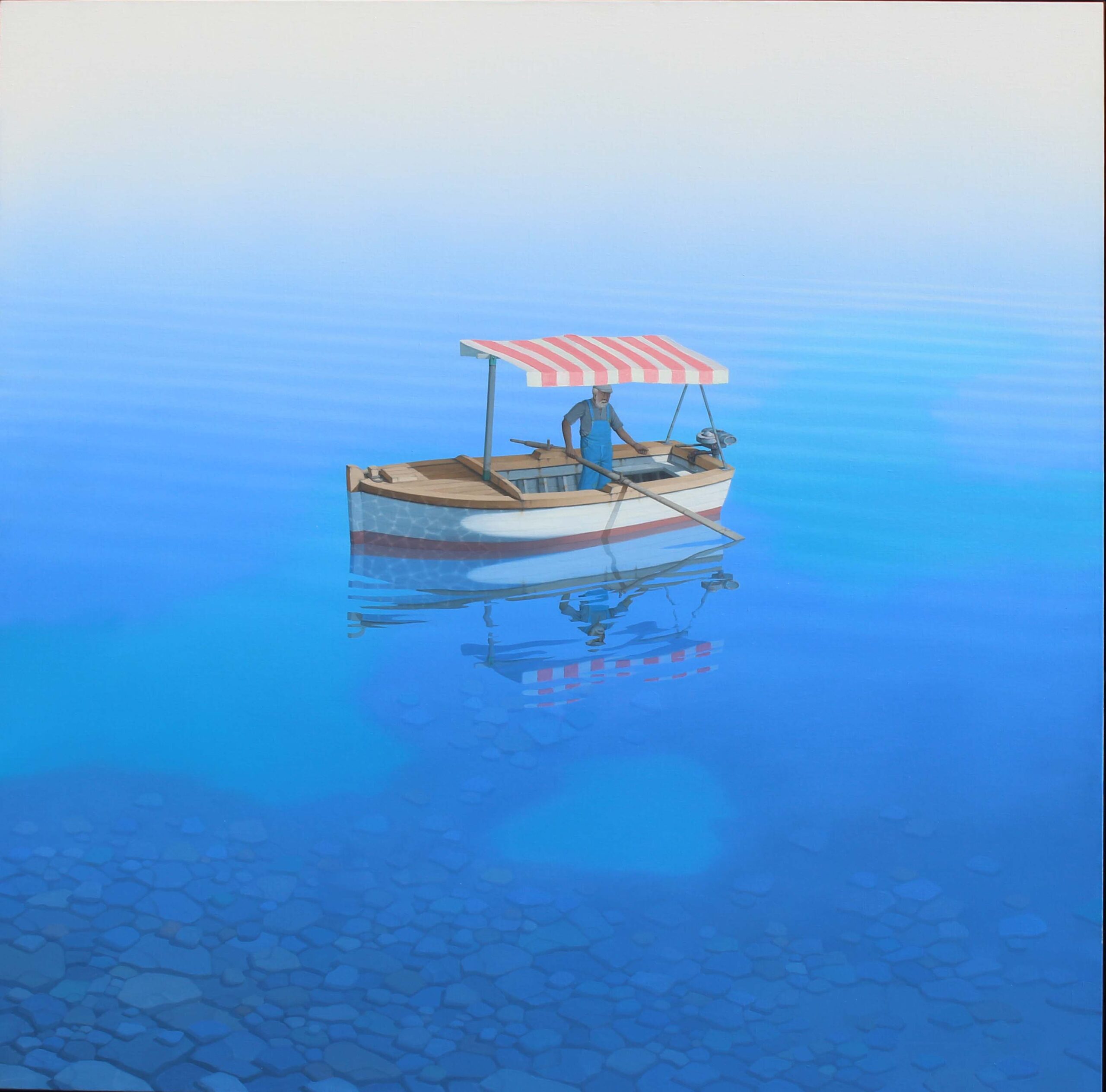 Solitary fisherman in a small boat with red and white striped canopy on calm, clear blue water revealing stones beneath under a pale sky.